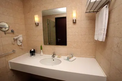 a bathroom with a sink and a mirror at Grand Tala Bay Resort, Aqaba in Aqaba