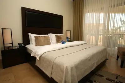 a bedroom with a large bed with a large window at Grand Tala Bay Resort, Aqaba in Aqaba