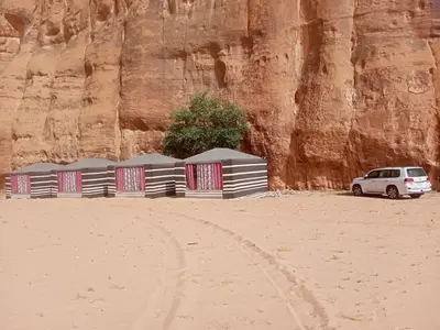 a white car parked in the desert near a mountain at Shahrazad desert, Wadi Rum in Wadi Rum