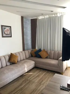 a living room with a couch and a television at AlQimah Hotel Apartments in Amman