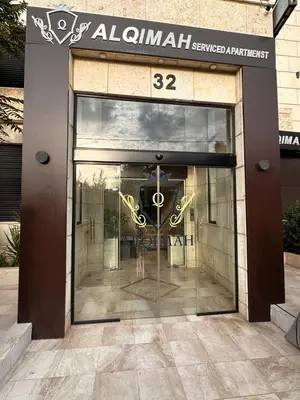 a store front with a glass door with a sign on it at AlQimah Hotel Apartments in Amman