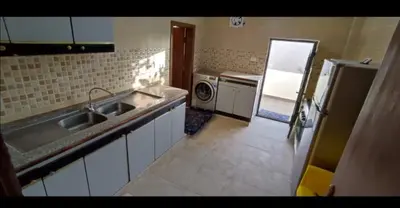 a kitchen with a sink and a refrigerator at the prince apartment شقة الامير in Wadi Musa