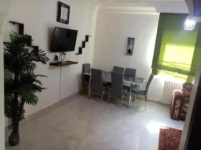 a dining room with a table and chairs and a tv at الفارس الوسيم للشقق الفندقيه in Amman