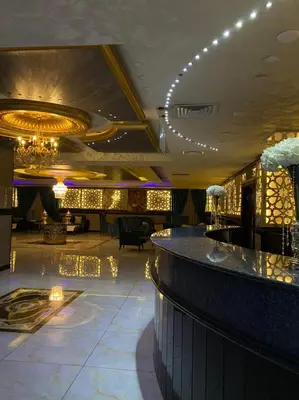 a lobby of a hotel with a bar and lights at The Castle Hotel in Amman
