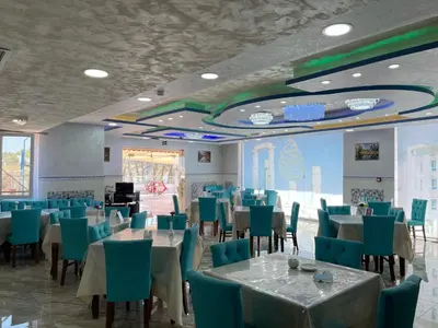 a dining room with tables and blue chairs at The Castle Hotel in Amman