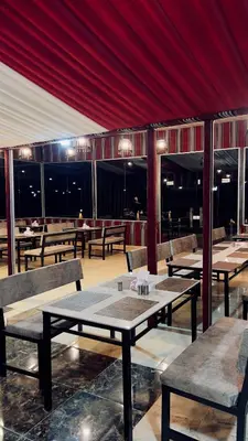 a restaurant with tables and chairs and a red ceiling at Osama Luxury Camp for Camping and Bubbles in Wadi Rum