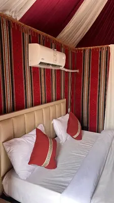 a bed with two red pillows on top of it at Osama Luxury Camp for Camping and Bubbles in Wadi Rum