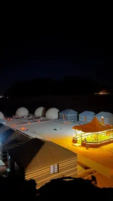 a group of white domed buildings at night at Osama Luxury Camp for Camping and Bubbles in Wadi Rum