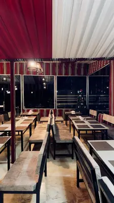 an empty restaurant with wooden tables and benches at Osama Luxury Camp for Camping and Bubbles in Wadi Rum