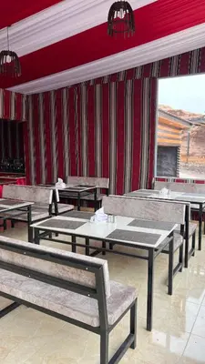 a restaurant with tables and benches in a room at Osama Luxury Camp for Camping and Bubbles in Wadi Rum