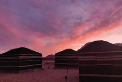 three large domes in the desert with a sunset at joy of life Camp in Wadi Rum