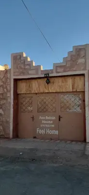 a building with two garage doors with the words real home at Petra bedouin house in Al Ḩayy