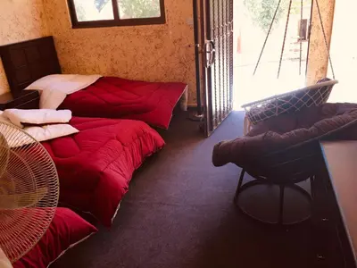 a room with two beds and a chair in it at Petra bedouin house in Al Ḩayy