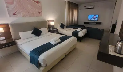 a hotel room with two beds and a television at Jordan View Hotel in Amman