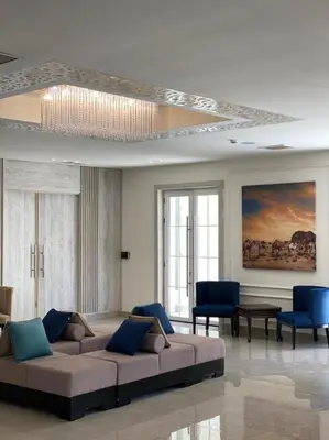 a living room with a couch and blue chairs at Jordan View Hotel in Amman