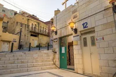 a building with a green door on a street at Jordan Heritage Madhafa in Al Salt
