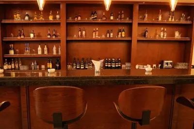 a bar with wooden chairs and bottles of alcohol at Baity Boutique Hotel in Aqaba