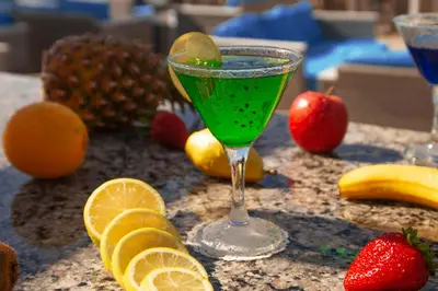 a green drink in a glass with fruit on a counter at Baity Boutique Hotel in Aqaba
