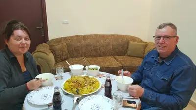 a man and woman sitting at a table with a plate of food at Petra Stones Inn in Wadi Musa