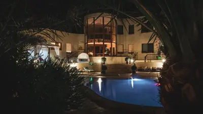 a house with a swimming pool at night at The Precious Villa in Sowayma