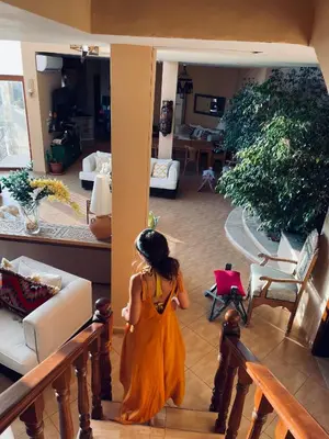 a young girl in an orange dress walking through a living room at The Precious Villa in Sowayma