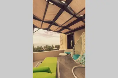 a living room with a green couch and a chair at The Precious Villa in Sowayma
