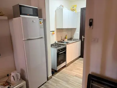 a kitchen with a white refrigerator and a stove at My Cosy little place in Amman