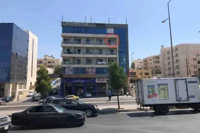 a street with cars parked in front of a building at My Cosy little place in Amman