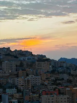 a city skyline with a sunset in the background at Cleopetra Hotel in Wadi Musa
