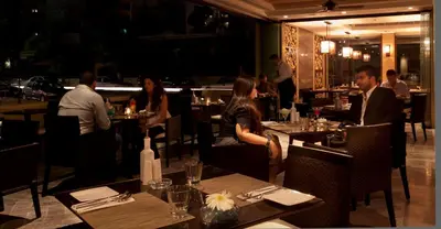 a group of people sitting at tables in a restaurant at AlQasr Metropole Hotel in Amman