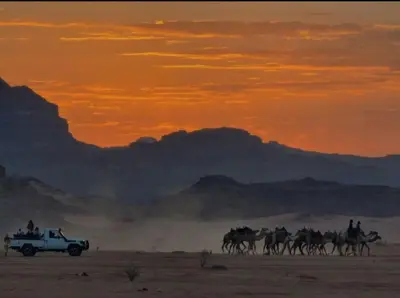 a group of people riding horses in the desert at sunset at orbit camp 2 in Wadi Rum