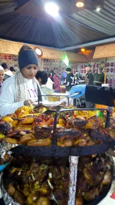 a woman standing next to a table of food at orbit camp 2 in Wadi Rum