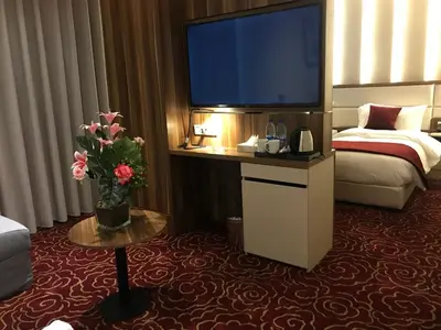 a hotel room with a large television and a bed at Lilac Hotel - Amman in Amman