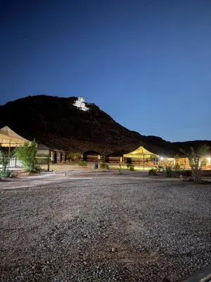 a parking lot in front of a mountain at night at Shakria Bedouin Life Camp in Wadi Rum
