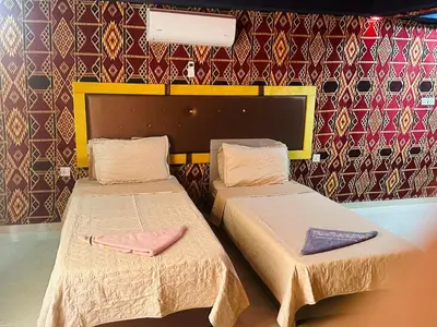 two beds in a room with a wall at Shakria Bedouin Life Camp in Wadi Rum