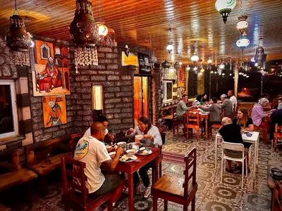 a group of people sitting at tables in a restaurant at Petra Desert Dream Hotel in Wadi Musa