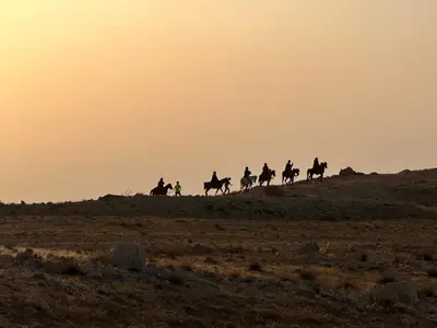 a group of people riding horses on a hill at Petra Desert Dream Hotel in Wadi Musa