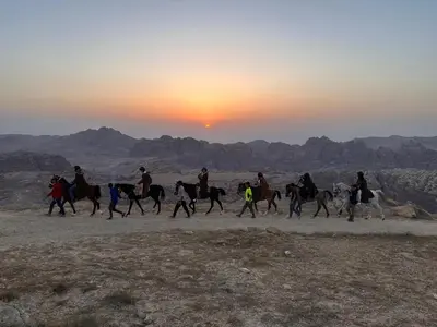 a group of people riding horses in the desert at Petra Desert Dream Hotel in Wadi Musa