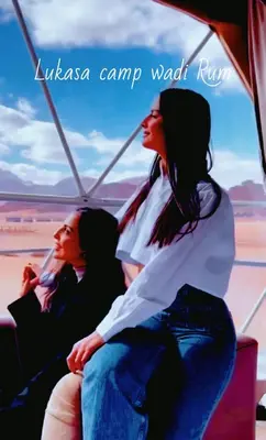 two women sitting on a tiki camel wagon at Lukasa camp Wadi Rum in Wadi Rum