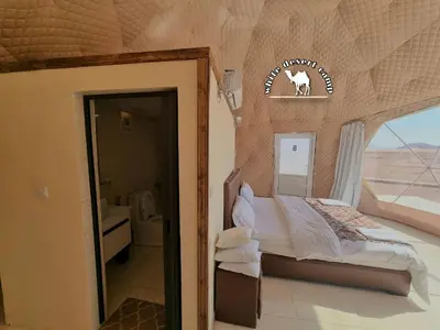 a bedroom with a bed in a room with a window at White Desert Camp in Wadi Rum