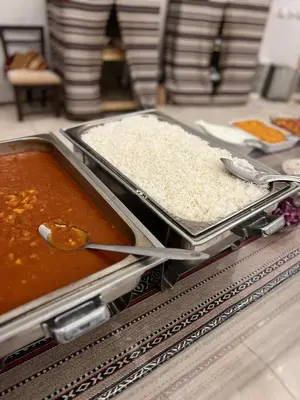 a buffet with two trays of food with rice at White Desert Camp in Wadi Rum