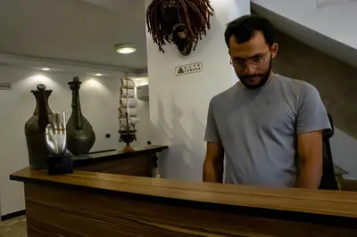 a man standing in front of a counter at Celestia Boutique Inn in Jerash
