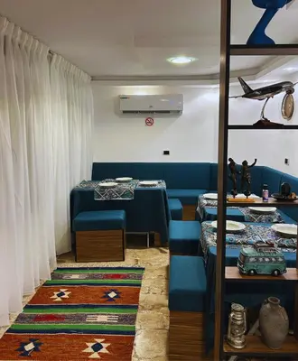 a dining room with blue chairs and tables and a room with at Celestia Boutique Inn in Jerash