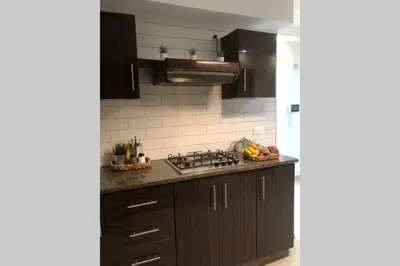 a kitchen with brown cabinets and a stove top oven at Luxury Apartment in Awesome Location in Amman in Amman