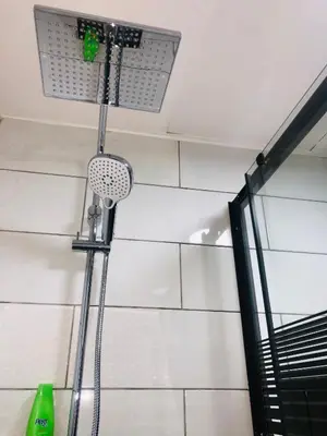 a shower head in a bathroom next to a wall at Luxury Apartment in Awesome Location in Amman in Amman