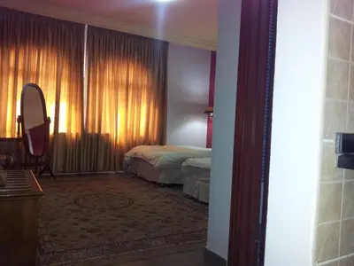 a bedroom with a bed and a window with curtains at Rana Palace in Amman