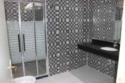 a bathroom with a shower and a toilet and a sink at Rana Palace in Amman