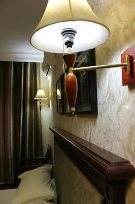 a lamp hanging over a bed in a hotel room at Rana Palace in Amman