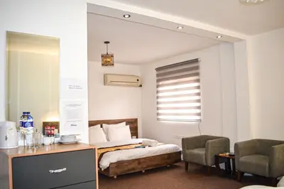 a bedroom with a bed and a desk and chairs at Hikaya studios in Wadi Musa