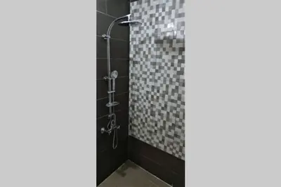a bathroom with a shower with black tiles at Hikaya studios in Wadi Musa